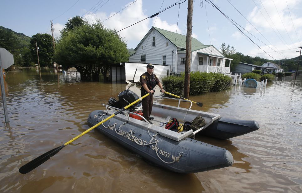 Lt. Dennis Feazell, of the West Virginia Department of Natural Resources, rows a boat as he and a co-worker search flooded homes in Rainelle on June 25. 