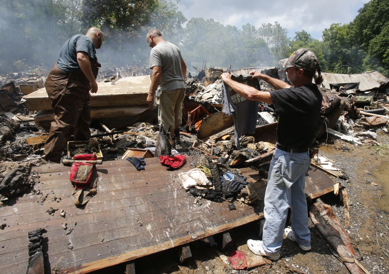 Ron Scott recovers a shirt from the remnants of his home after it was swept off its foundation and burned in White Sulphur Springs, West Virginia, on June 24. 