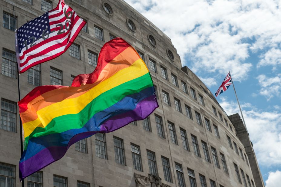  An American flag with the date of the Orlando shootings flies above a rainbow flag with a Union Jack in the distance during London's Pride march on June 25. 