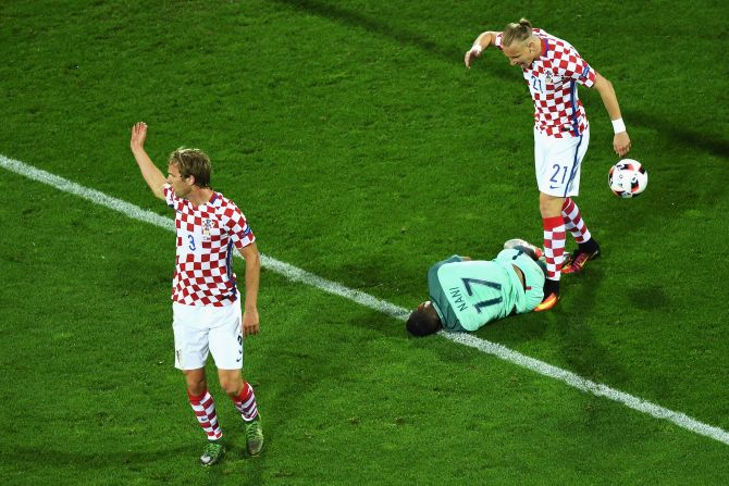 Ivan Strinic, left, and Domagoj Vida, right, of Croatia protest as Portugal forward Nani falls in the penalty area.