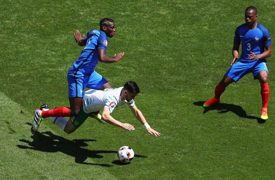 Shane Long of Ireland is challenged by Paul Pogba of France.