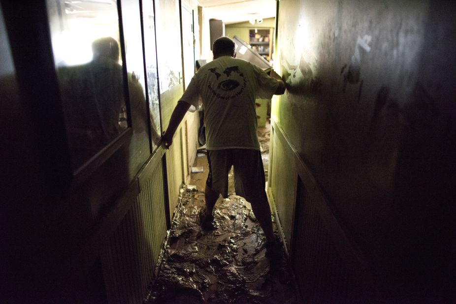 Larry Brooks walks down the muddy hallway of his trailer in Elkview, West Virginia, on June 25. Brooks said he lost about 95% of the personal belongings in his home. 