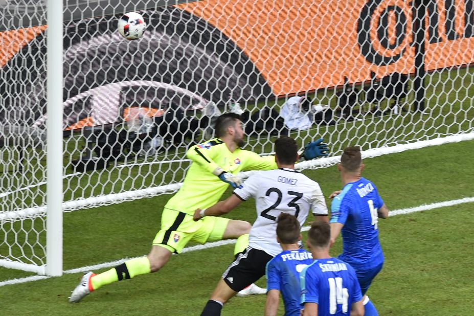 Germany's forward Mario Gomez, center, scores against Slovakia's goalkeeper Matus Kozacik.