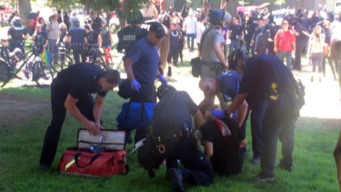A man injured during the rally is assisted by police and emergency personnel.