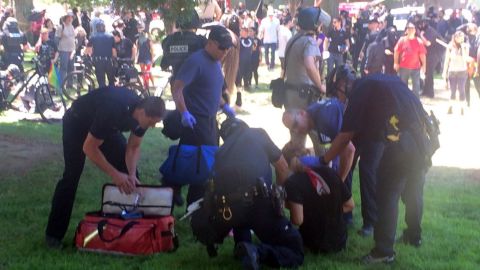 A man injured during the rally is assisted by police and emergency personnel. 