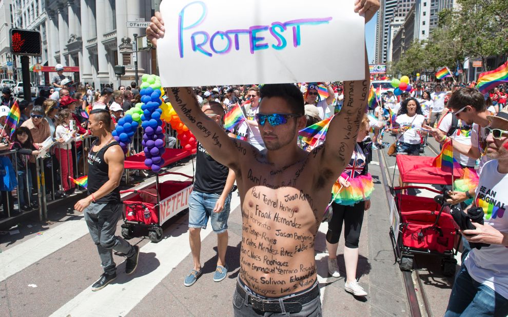 Thomas Pedroza marches along the San Francisco parade route with the names of the Orlando shooting victims written on his body.