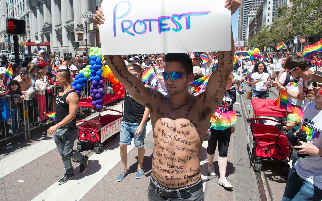 Thomas Pedroza marches along the San Francisco parade route with the names of the Orlando shooting victims written on his body.