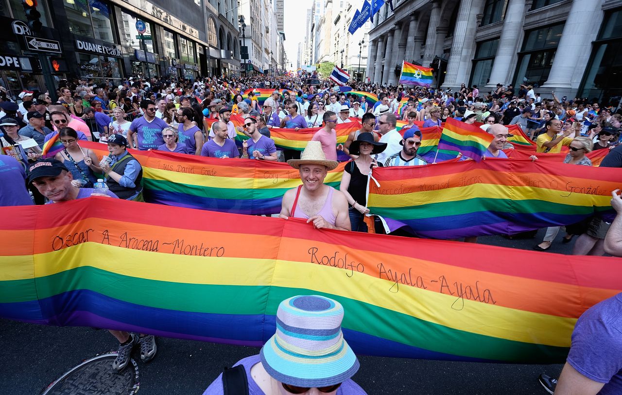 Marchers in New York carry rainbow flags.