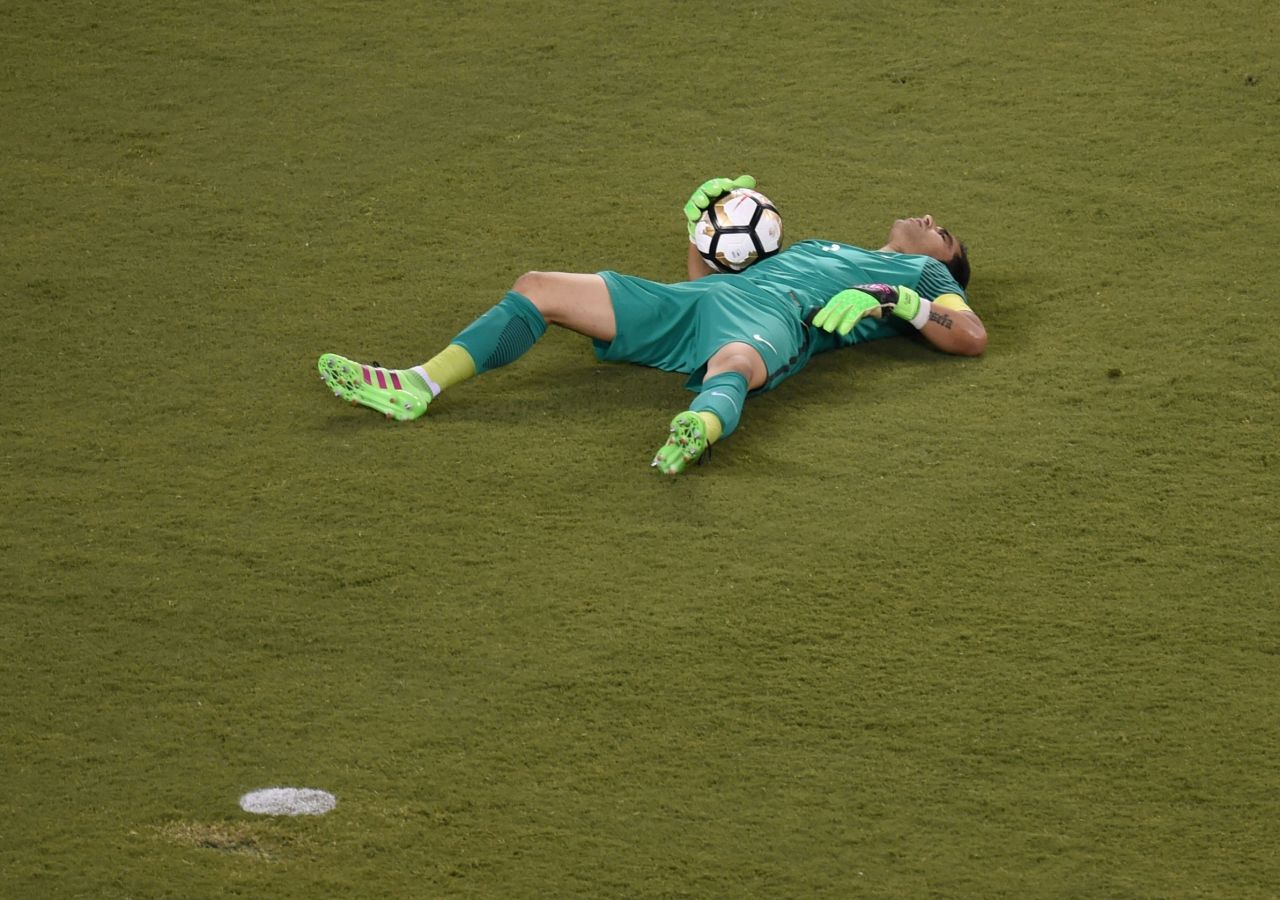 Chile's goalkeeper Claudio Bravo lies on the ground.