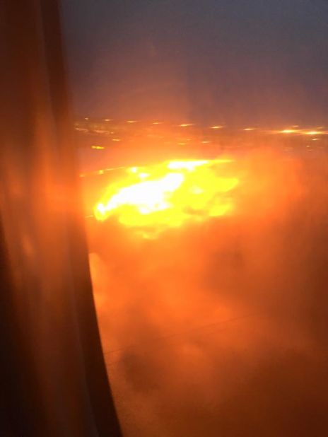 A cell phone photo shot by passenger Lee Bee Yee (facebook.com/premiummall.sg) shows the wing of a Singapore Airlines flight on fire upon landing at Changi Airport on June 27, 2016. 