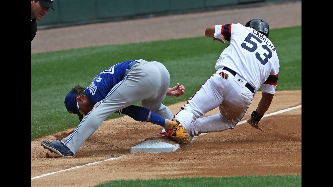 Melky Cabrera of the Chicago White Sox appears to slide safely into third as Josh Donaldson tries to make a tag on Sunday, June 26.