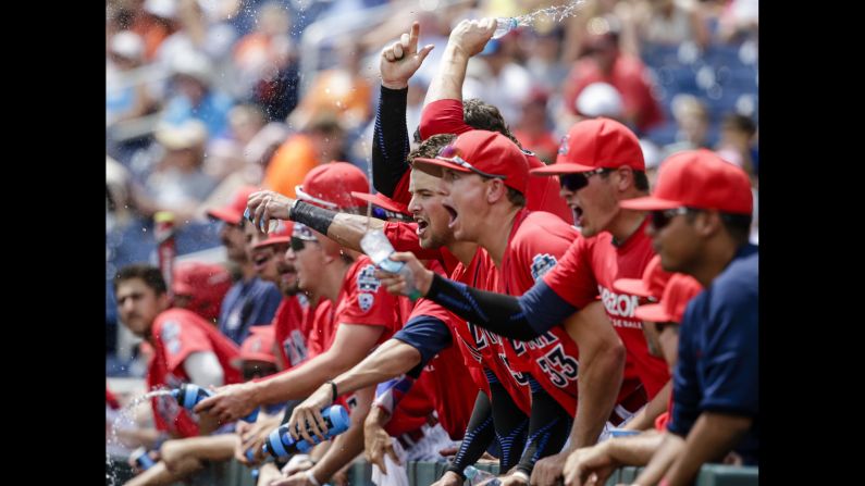 Arizona players celebrate in the dugout after Kyle Lewis scored a run against Oklahoma State during a College World Series game on Saturday, June 25.