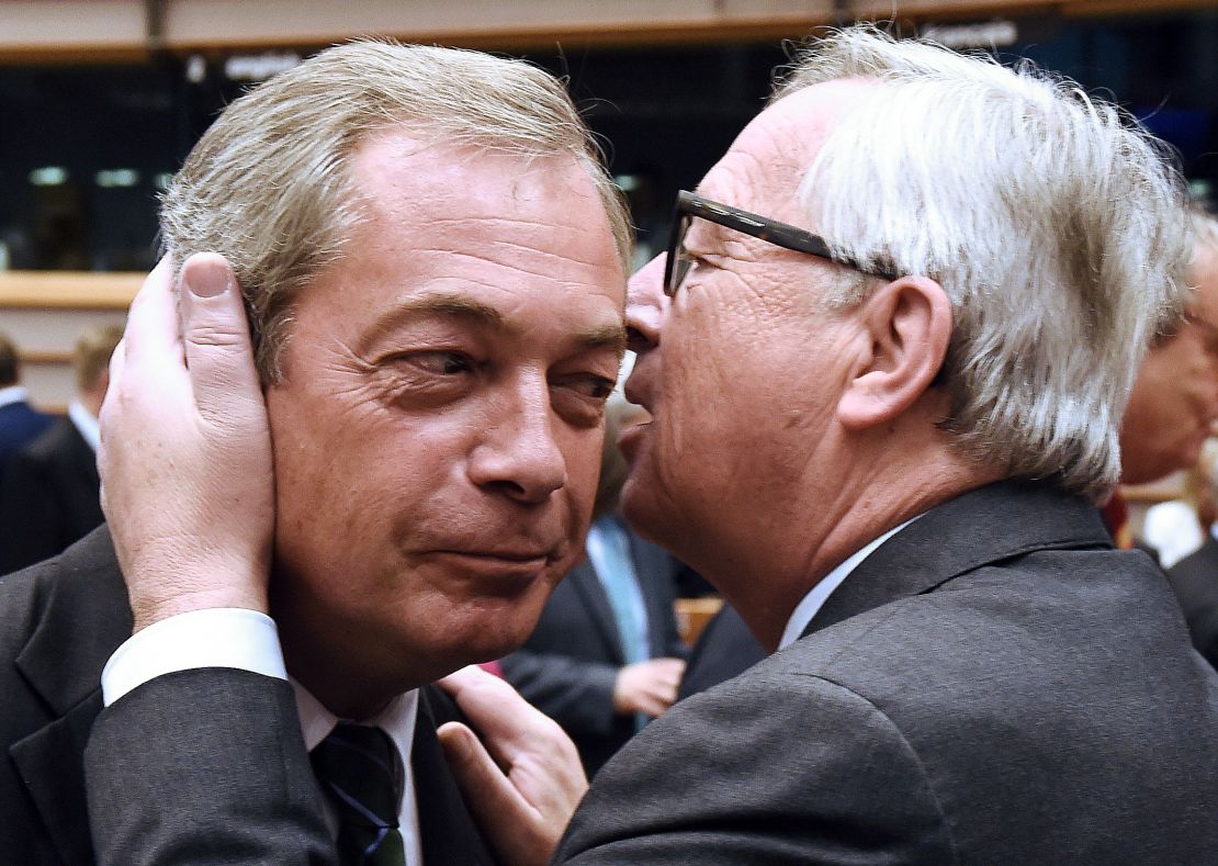 European  Commission President Jean-Claude Juncker speaks in the ear of UK Independence Party leader Nigel Farage Tuesday.