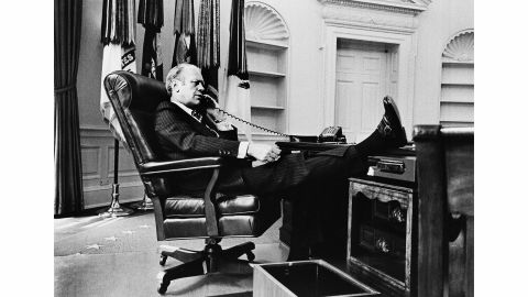 President Gerald R. Ford talks on the telephone in the Oval Office shortly after replacing Richard Nixon. "The empty shelves in the background are a clue to how fast the transition occurred with all of the former President's things taken out with no time to replace them with Ford mementos," Kennerly said.
