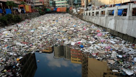 Building reflected in the waters of a garbage filled river in Manila on January 23, 2016. 