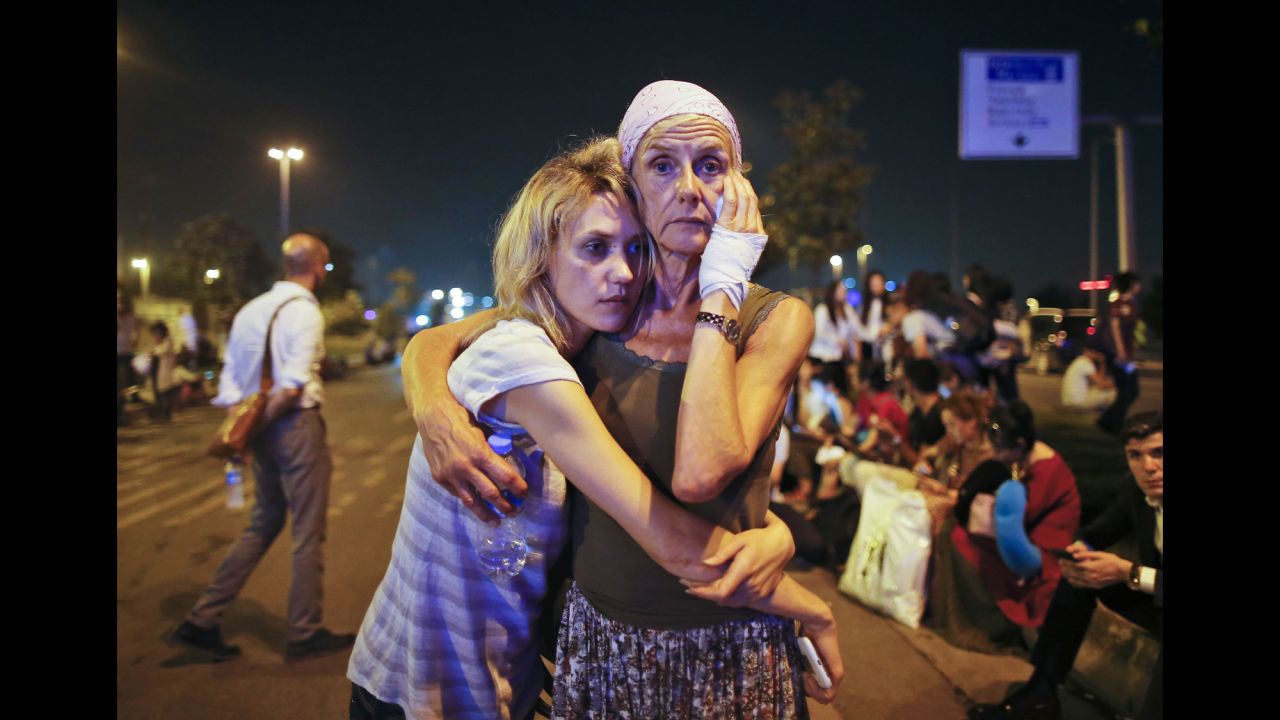 Travelers embrace outside the airport.