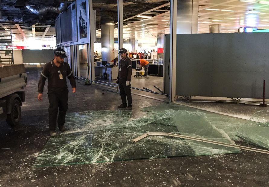 Workers clear glass debris on the day after the attack.