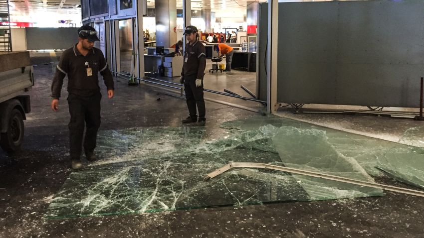Authorized personnel clear glass debris in Ataturk airport's International arrival terminal on Wednesday, June 29.