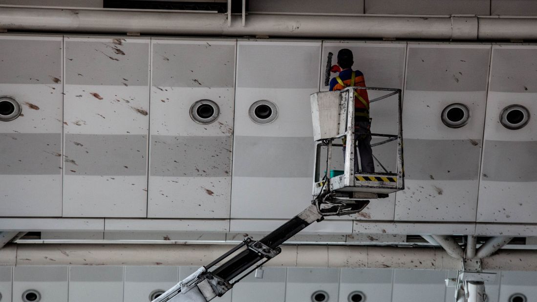 A worker cleans blood from the upper walls of the international departure terminal.