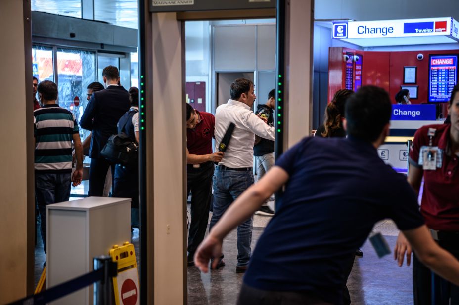 Security personnel scan passengers and employees at a checkpoint on June 29.