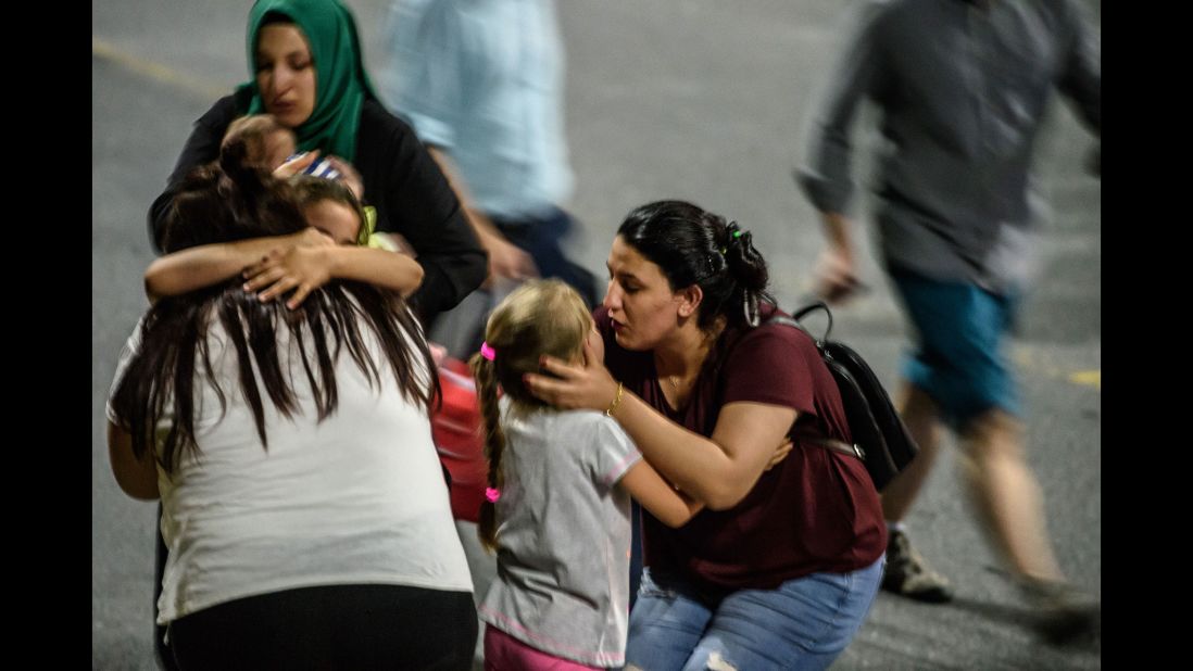 Children and their relatives embrace after reuniting outside the airport.