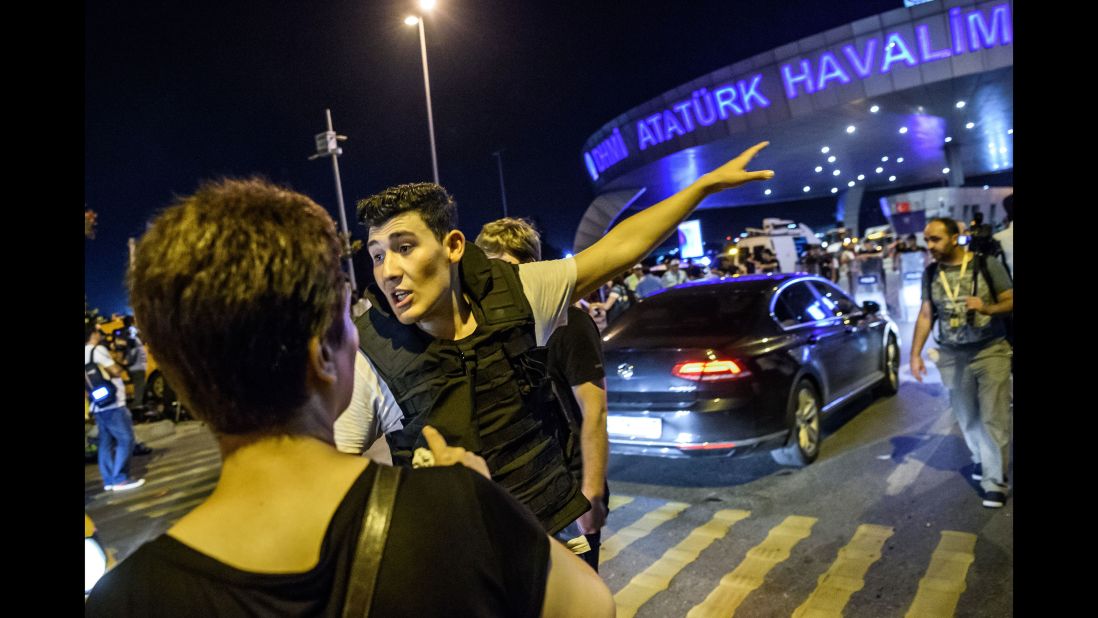 A Turkish police officer directs a passenger at the airport.