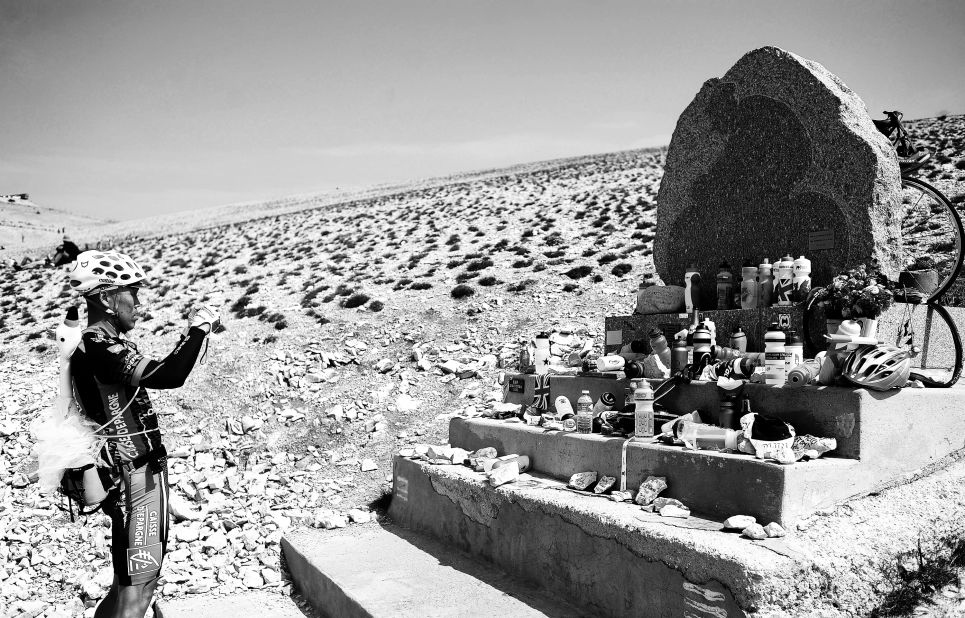 A spectator takes a photo of the Tommy Simpson memorial on Mont Ventoux. British cyclist Simpson died on the mountain during the 1967 Tour de France.