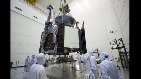 Technicians use a crane to lower Juno onto a stand where the spacecraft was loaded with fuel for its mission.