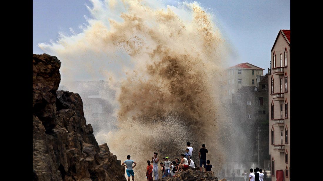Residents of Wenling, China gather to see huge waves stirred up by strong wind as Typhoon Soudelor draws near in 2015.