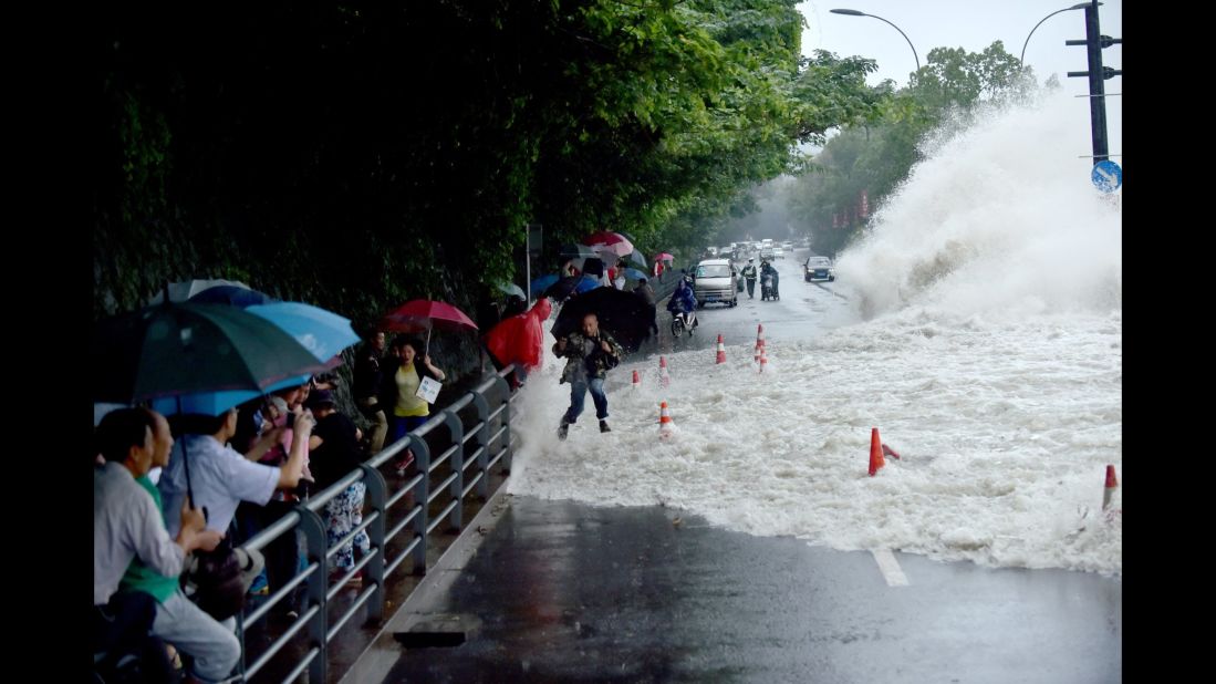 Spectators are swept by huge waves brought by Typhoon Dujuan while watching tides of Qiantang River at a dike on September 29, 2015 in Hangzhou, China. 