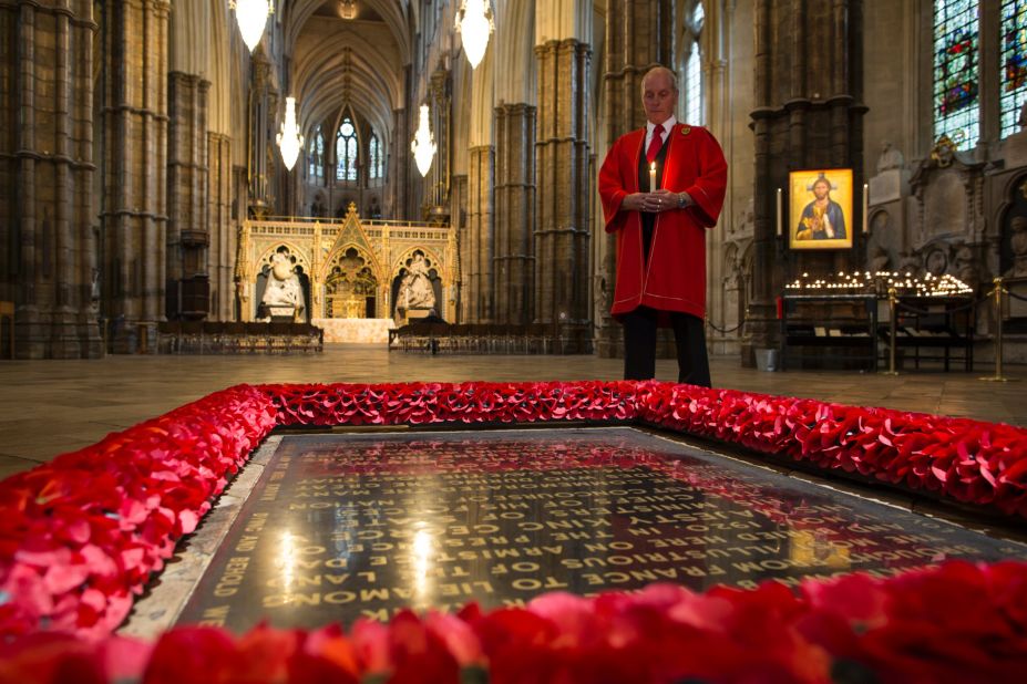 An abbey marshal poses next to "The Grave of the Unknown Warrior" in London's Westminster Abbey.