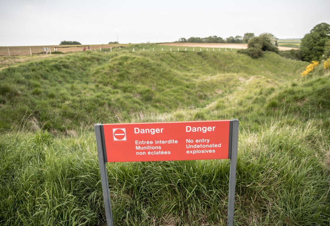 A sign marks the hidden dangers of undetonated explosives where the outline of trenches can still be seen at Newfoundland Memorial Park in Beaumont-Hamel, France.