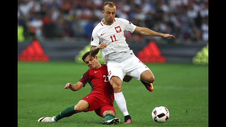 Portugal's Cedric Soares tackles Poland's Kamil Grosicki.