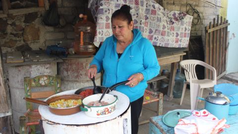 Martha Mendoza cooks on her makeshift firewood stove.
