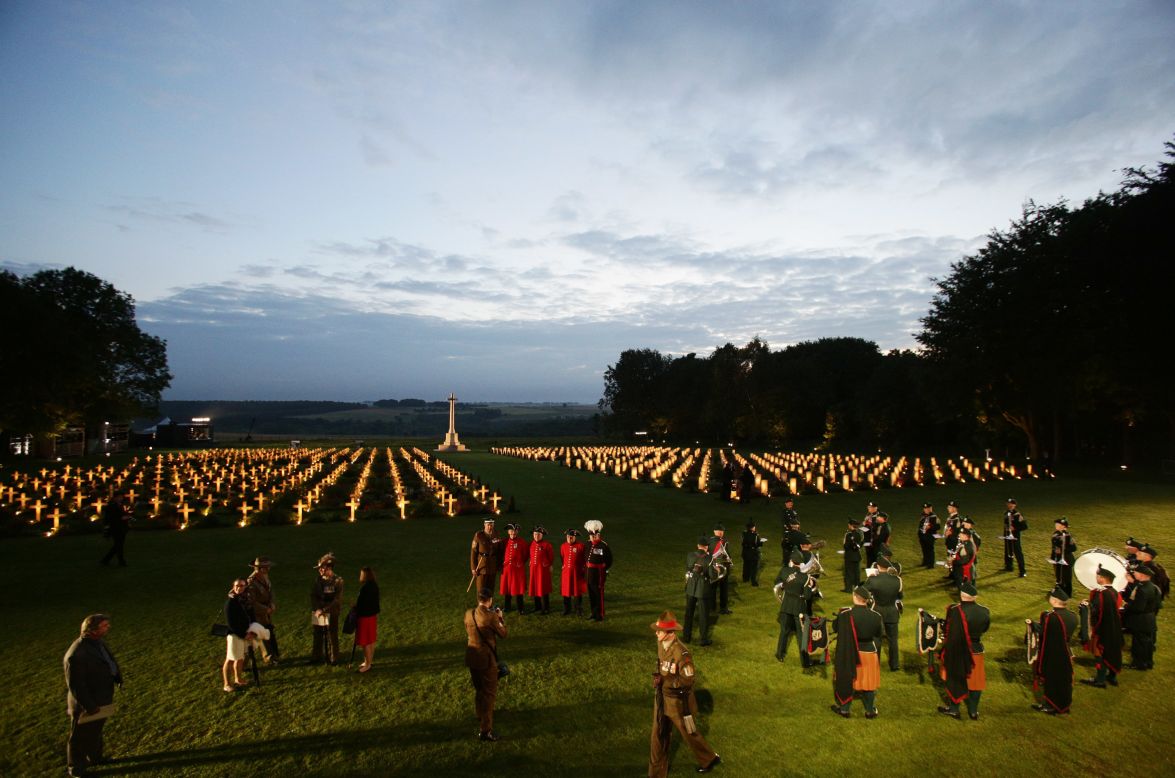 Attendees are seen among the illuminated graves of the Thiepval Memorial to the Missing.
