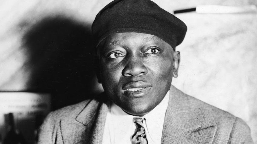 Portrait of American boxer, heavyweight champion and inventor Jack Johnson (1878 - 1946) smoking a cigar, circa 1930s.