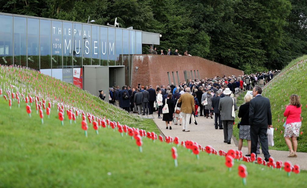 Visitors to the Thiepval Museum pass artificial poppies planted at the entrance to the museum with handwritten messages of commemoration to those who died at the Battle of the Somme.