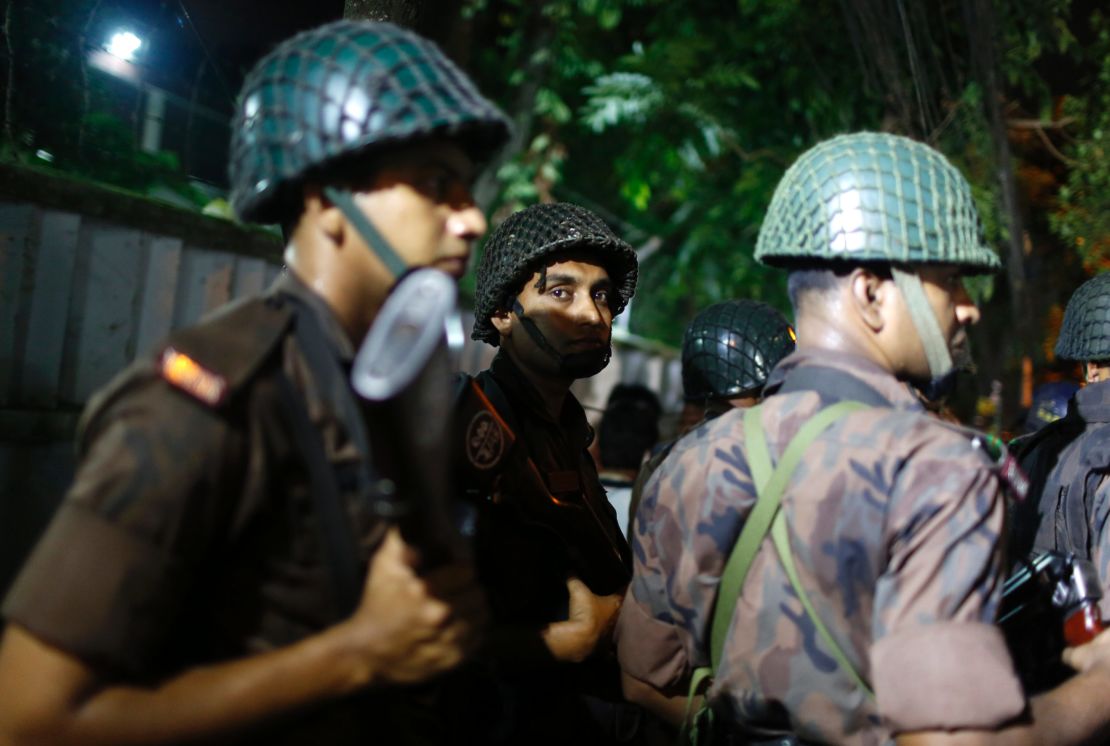 Bangladeshi security personnel stand guard near the restaurant. 