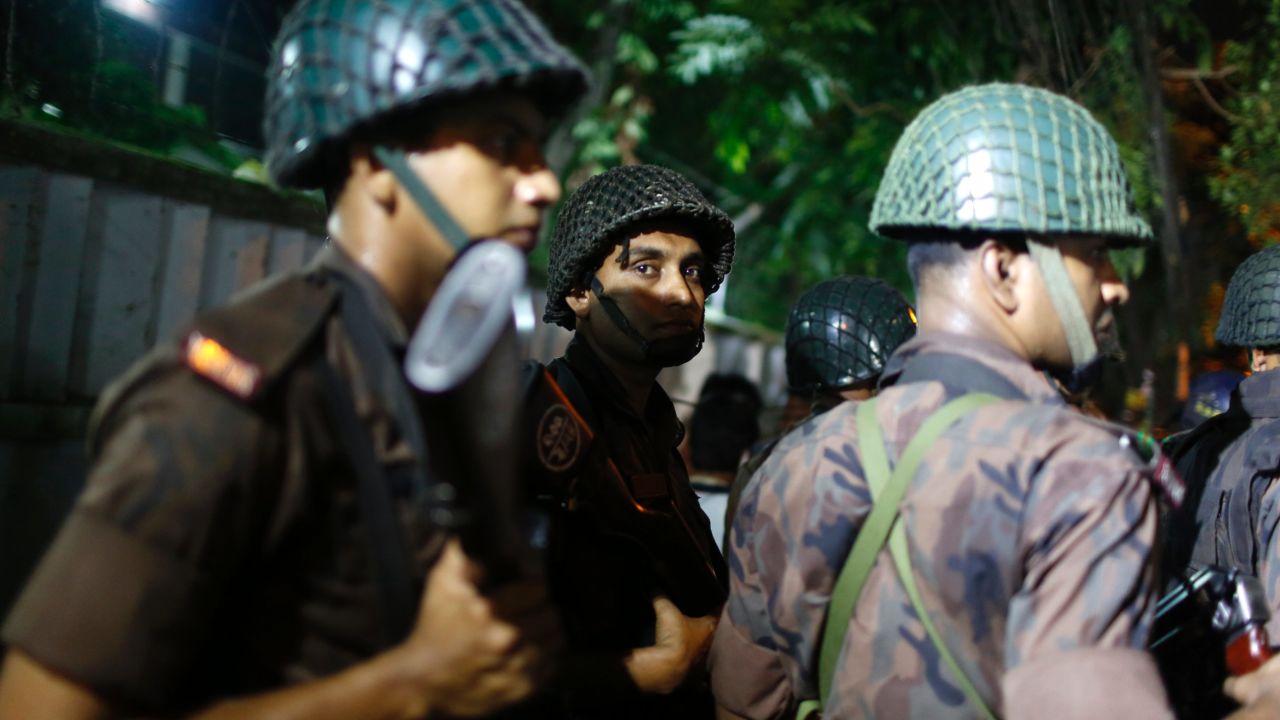 Bangladeshi security personnel stand guard near the restaurant. 