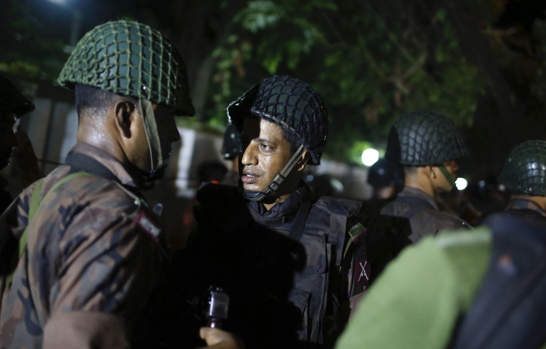 Bangladeshi security personnel stand guard near the restaurant.