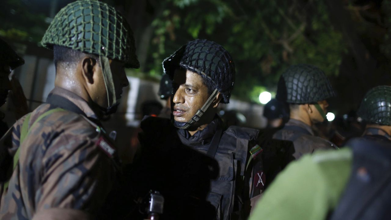 Bangladeshi security personnel stand guard near the restaurant.