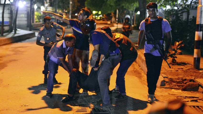 People help an unidentified injured person after a group of gunmen attacked a restaurant popular with foreigners in a diplomatic zone of the Bangladeshi capital Dhaka, Bangladesh, Friday, July 1, 2016. A group of gunmen attacked a restaurant popular with foreigners in a diplomatic zone of the Bangladeshi capital on Friday night, taking hostages and exchanging gunfire with security forces, according to a restaurant staff member and local media reports.