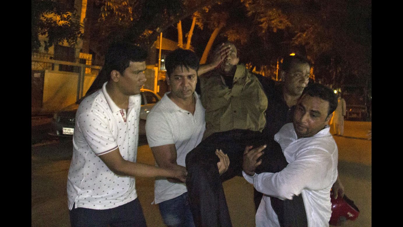 People carry an injured man near the cafe.