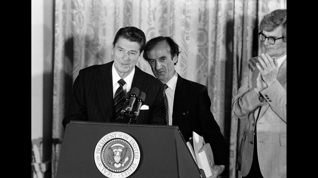 Then-President Ronald Reagan and Elie Wiesel (behind Reagan), chairman of the United States Holocaust Memorial Council, take part in a "day of remembrance" ceremony in the East Room of the White House on April 30, 1981.