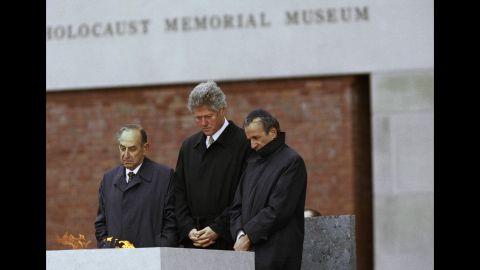 Elie Wiesel, right, stands beside then-President Bill Clinton, center, and Bud Meyerhoff, left, chairman of the U.S. Holocaust Memorial Council, after lighting the eternal flame during the dedication ceremony for the U.S. Holocaust Memorial Museum in Washington, April 22, 1993.