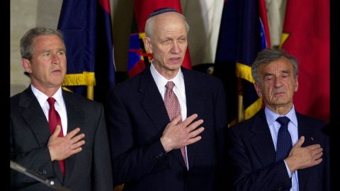 Then-President George Bush, left; Rabbi Irving Greenberg, center; and Elie Wiesel, right, sing the national anthem during a national commemoration of the Days of Remembrance for victims of the Holocaust, in the Capitol rotunda on April 19, 2001, in Washington. 
