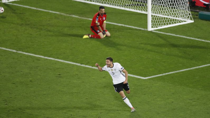 Italy's Gianluigi Buffon looks as Germany's Jonas Hector celebrates his decisive penalty shot.