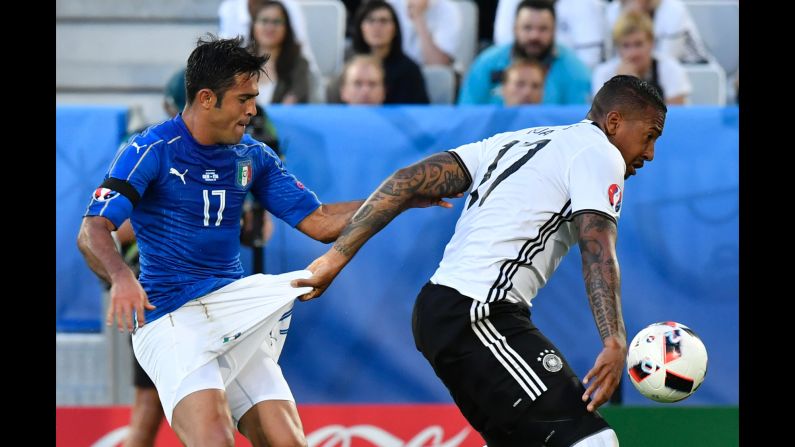 Germany defender Jerome Boateng, right, grabs the shorts of Italy forward Citadin Martins Eder while vying for the ball.