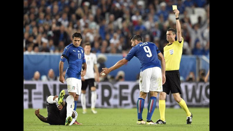 Referee Viktor Kassai shows a yellow card to Italy's Graziano Pelle. By the end of the match, Italy was given five yellow cards and Germany two.