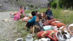 Pakistani children affected by flooding sit on higher ground in the village of Nagar in Chitral on July 3, 2016.